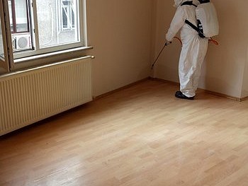 İnşaat sonrası temizlik yapılan boş daire, koruyucu tulumlu çalışan
